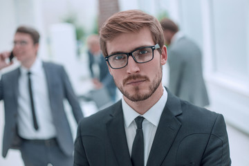 serious young businessman on an office background .