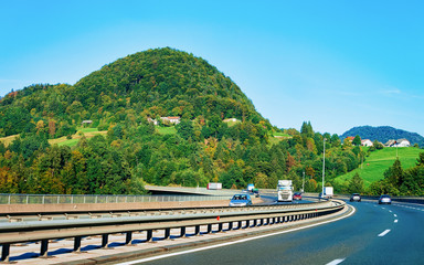 Scenic landscape and cars in the road in Slovenia. Julian Alps on the background.