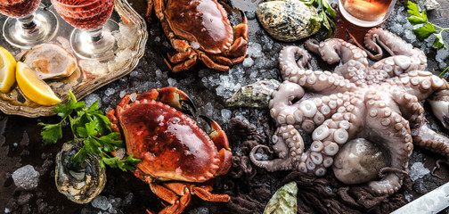 Zusammenstellung von Meeresfrüchten mit feinschmeckerischem Abendessenhintergrund der rohen frischen Krake,austern und mit roten krabben