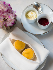 A tasty and delicious set of freshly baked scones with clotted cream and jam for afternoon tea or...