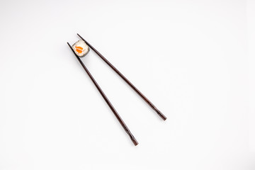 roll between chopsticks for sushi on a light background for the menu3