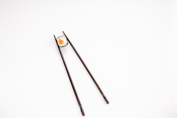 roll between chopsticks for sushi on a light background for the menu5