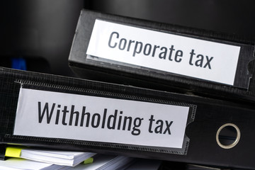Stack of taxes binders report concept: Document of Withholding tax and corporate tax for accountant. withholding tax sometimes applies to royalties, rent or even sale duty must be paid to government