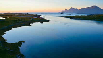 Sunset on Lofoten Islands. Landscape panorama of blue sea with mountain in background.