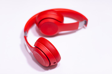 Red, stylish, bluetooth wireless headphone on white background.