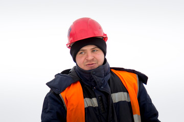 Portrait of a worker in an orange helmet at the workplace