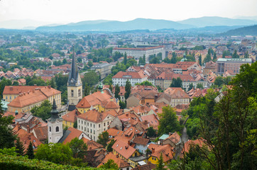 Fototapeta na wymiar Ljubljana church tower aerial view. Panorama of city with beautiful historical church. The Slovenian mountains in the background. Look to Slovenia capital city.