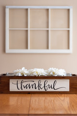 White flowers in a rustic wooden container with the word thankful