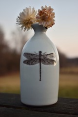 Flower in white dragonfly vase