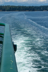 blue water churning in the puget sound along the side of a ship