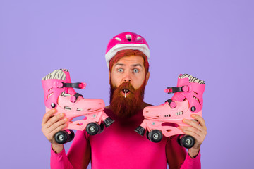 Roller skater. Rollerblading. Bearded man with roller skating. Handsome man with roller skates. Inline skating. Man in protective helmet holds roller blades. Active sport. Protective sport equipment.