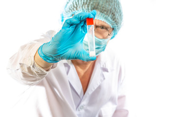 Naklejka premium lab technician looks at a test tube of clear liquid, coronavirus