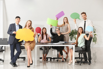 Group of business people with blank speech bubbles in office