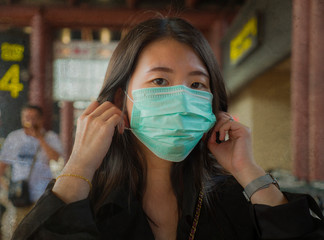 young beautiful and attractive Asian Chinese student at airport wearing protective facial mask...