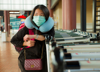young beautiful and attractive Asian Chinese student at airport wearing protective facial mask...