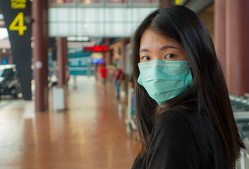 young beautiful and attractive Asian Chinese student at airport wearing protective facial mask...