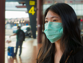 Fototapeta na wymiar young beautiful and attractive Asian Chinese student at airport wearing protective facial mask against China Coronavirus epidemic outbreak spreading breathing syndrome