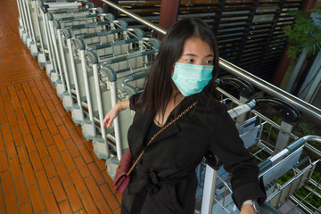 young beautiful and attractive Asian Chinese student at airport wearing protective facial mask...