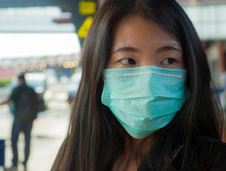 young beautiful and attractive Asian Chinese student at airport wearing protective facial mask...