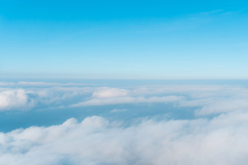 Fototapeta na wymiar Airplane window view above beautiful white cloud summer blue sky and sun light abstract nature.