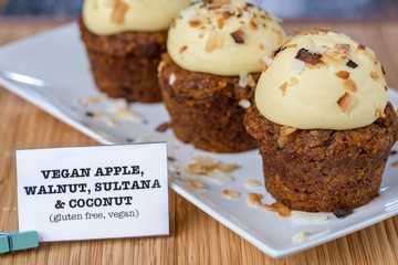 Three Vegan Apple, Walnut, Sultana and Coconut cupcakes, on a white plate.