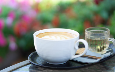 Closeup glass of latte art coffee tulip shape on wood background with vintage color, selective focus