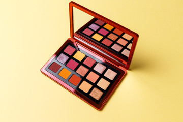Mua and girly concept. Eyeshadow palette on yellow background, eye shadows cosmetics product as luxury beauty brand promotion. Fashion blog design. Contouring palette. Makeup palette close up