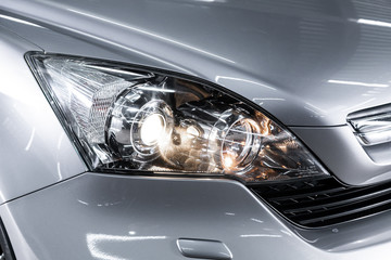 Silver car headlights. Exterior detail. Close up detail on one of the LED headlights modern car..