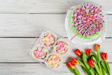 Flowers tulips dessert cake shot on white wooden background