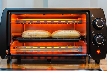 Peeled ripe banana in hot electric toaster, cooking banana toast.