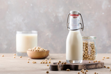 Soy milk and soy bean on gray table. Non-dairy milk concept. Vegan drink. Copy space
