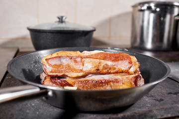 fried ribs of lamb. Cooking with fire in frying pan. Professional chef in a kitchen of restaurant cooking. Man frying food in flaming pan on hob.