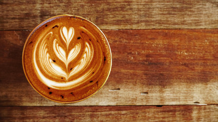 a cup of latte art coffee on wooden background                                                                                                                             