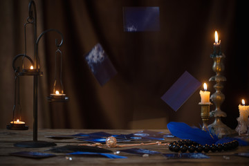 falling fortune-telling cards over  wooden table in the light of candles