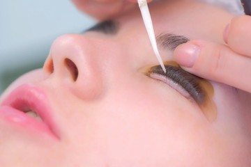 Cosmetologist bending lashes with needle into curlers, lift eyelashes laminaton procedure in beauty...