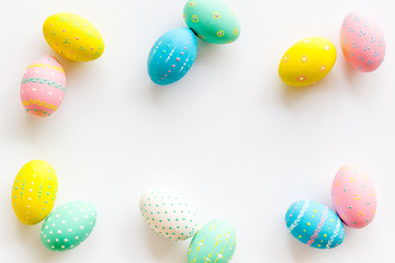 Fototapeta na wymiar Colorful Easter eggs frame on white background top-down copy space