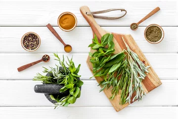 Herbs and spices on white wooden kitchen desk top-down © 9dreamstudio