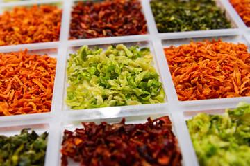 Sublimated thinly sliced vegetables. Dried cabbage. Dry carrots and beets are strewn in neighboring cells.