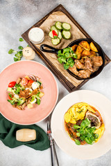Meat and potatoes in a pan with salad