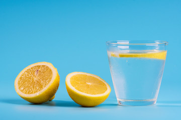 Lemonade with fresh lemons on blue background.  Selective focus. Copyspace concept.