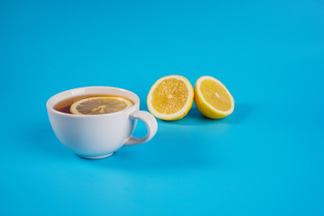 A cup of a lemon tea overblue background.