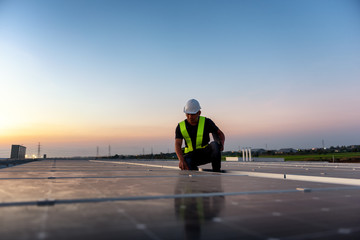 Technician checking Photovoltaic cells panels on factory roof, Maintenance of the solar panels,...