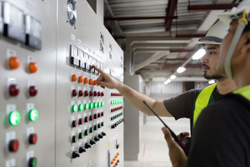 Electrical Engineer team working front HVAC control panels, Technician daily check controls system...