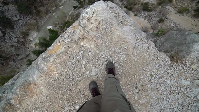Crazy man walking towards the cliff. Extreme high rocky abyss. Point of view pov camera. A very dangerous madness. Ideal for suicide attempt, overcome fear, phobia threatening panic attack threat hike