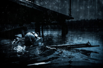 Military diver emerges from under the water and takes aim from the machine gun. The concept of...