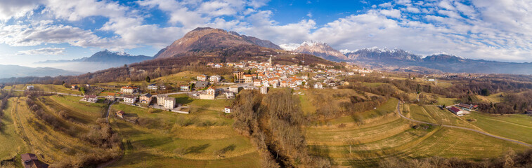 Fototapeta premium Panoramic view of Pieve D'Alpago - the old village in Dolomites Alps in Italy. Drone aerial panorama