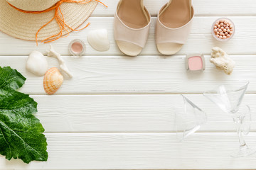 Female outfit. Clothes, shoes, cosmetics on white wooden background top-down frame copy space