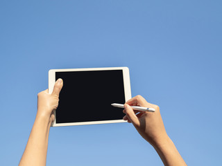 finger touching screen with blue backgroun, isolated on blue sky