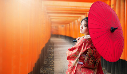 Asian woman tourists. Japanese girl wearing a kimono holding a red umbrella. Beautiful Female...