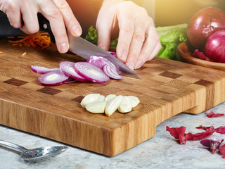 Obraz na płótnie Canvas Closeup of a male cook cuts raw onions